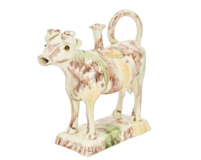 Lot 629 - A creamware Whieldon type cow creamer and cover.