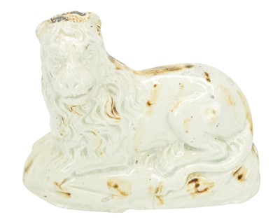 Lot 633 - An English creamware figure of a recumbent lion.