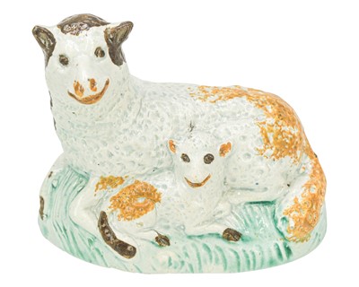 Lot 611 - A pearlware figure of a recumbent sheep and lamb.