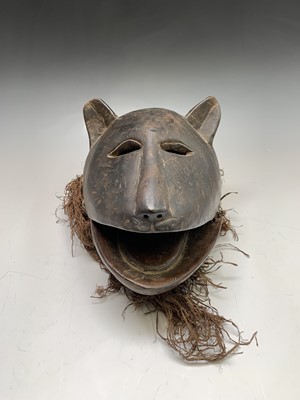 Lot 276 - An African carved wood mask of feline form....