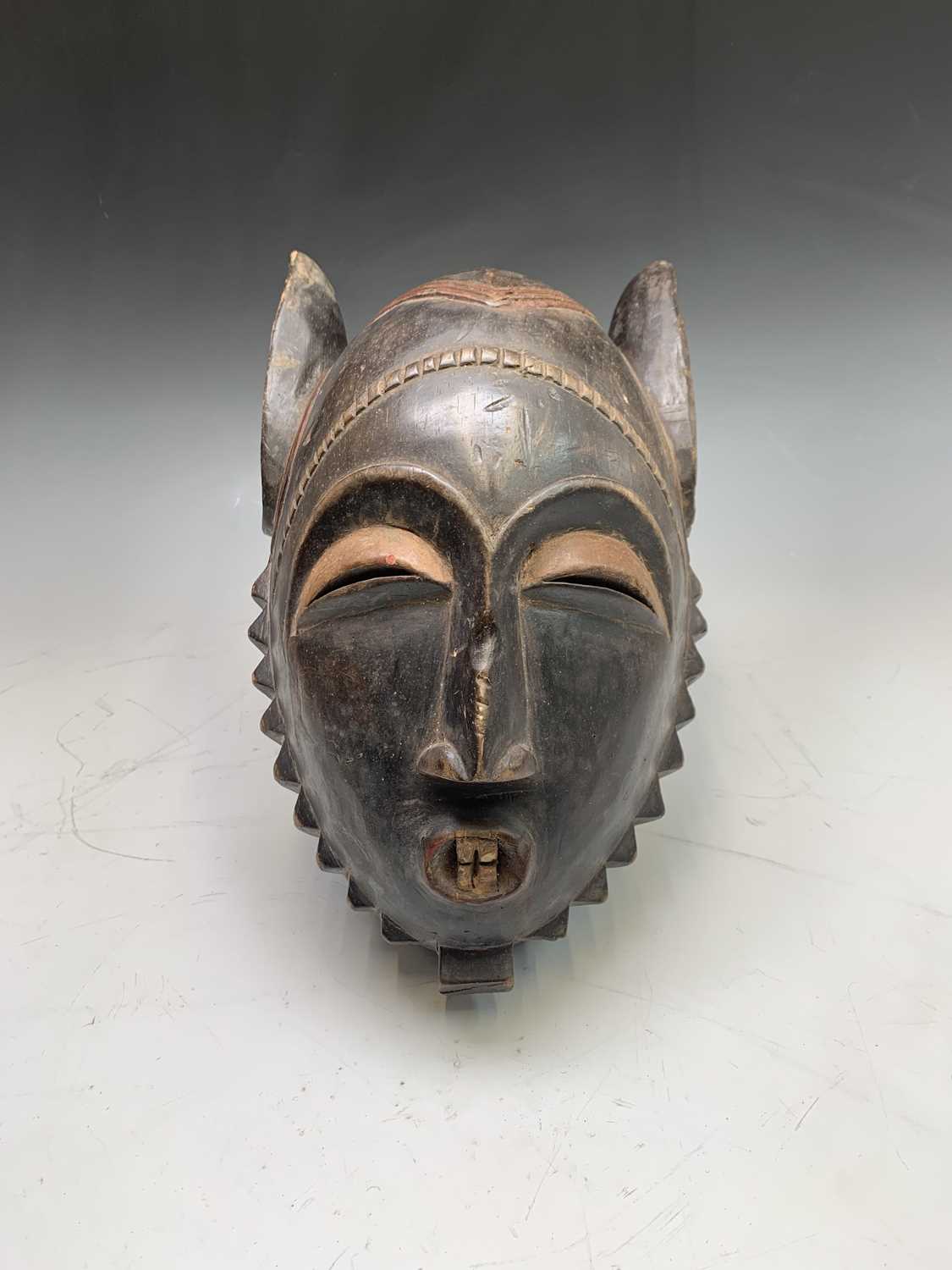 Lot 20 - An African carved wood and painted tribal mask,...