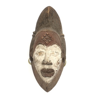 Lot 90 - An African carved wood mask, painted in red...