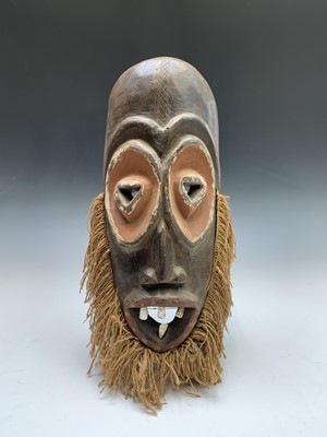 Lot 183 - An African carved wood mask of elongated form,...