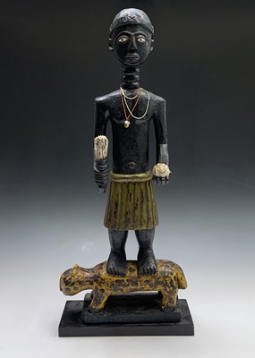 Lot 181 - An African carved wood figure of a man...
