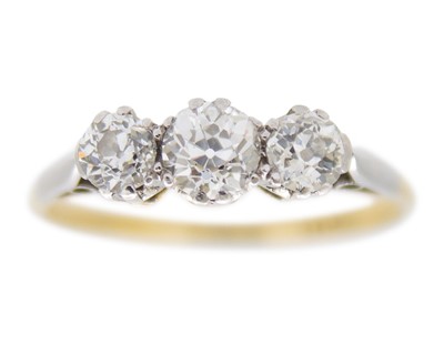 Lot An 18k yellow and white gold old mine cut diamond set three-stone ring.