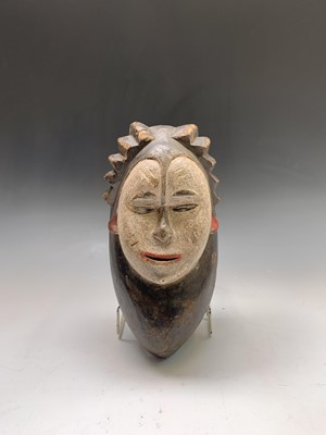Lot 101 - A tribal mask, carved and painted in black,...