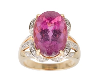 Lot 205 - An 18k dress ring, set with a large oval cut rubellite tourmaline and pavé set diamonds.