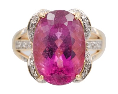 Lot 205 - An 18k dress ring, set with a large oval cut rubellite tourmaline and pavé set diamonds.
