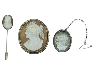 Lot 422 - A selection of silver-mounted cameo shell brooches and stick pin.