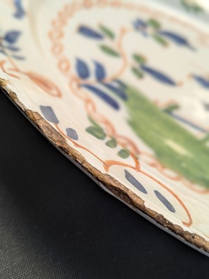 Lot 627 - A pair of English Delft polychrome chargers.