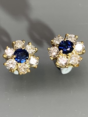 Lot 2407 - A pair of cluster earrings each set a sapphire...