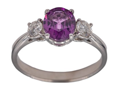Lot 270 - An attractive purplish pink garnet and diamond set platinum three-stone ring.