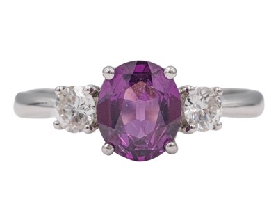 Lot 270 - An attractive purplish pink garnet and diamond set platinum three-stone ring.