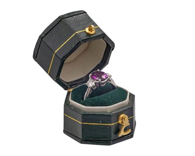 Lot 270 - An attractive purplish pink garnet and diamond set platinum three-stone ring.