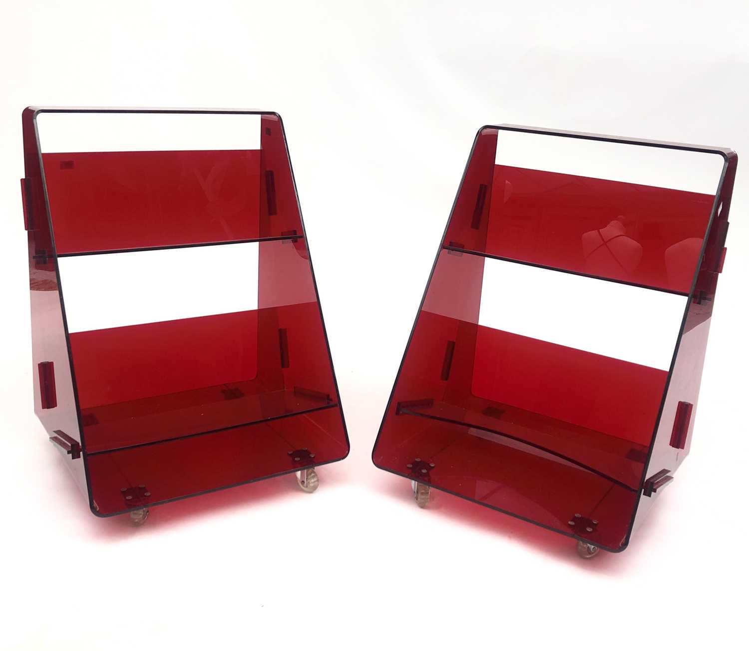 Lot 5 - A pair of red acrylic library book caddies by...