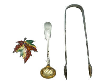 Lot 192 - A Victoria silver pair of sugar tongs, a Victoria silver mustard spoon, and a silver and enamel maple leaf brooch.