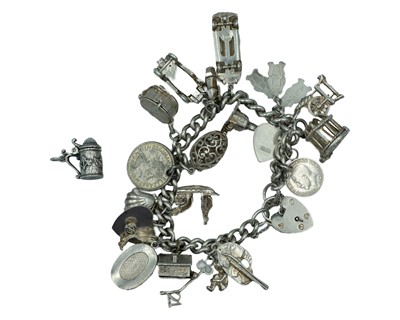 Lot 438 - A silver curb-link charm bracelet applied with numerous silver charms & a silver-plated QEII farthing coin.
