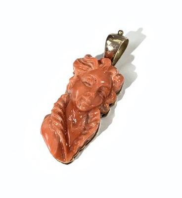 Lot 2398 - A carved red coral gold-mounted pendant