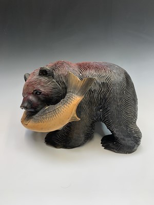 Lot 153 - A carved wood bear with a salmon in its mouth...