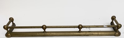 Lot 688 - A late Victorian brass fender with tubular top...