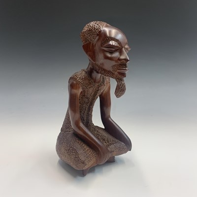 Lot 360 - An African carved hardwood figure of a seated...