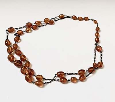 Lot 154 - A long necklace of amber beads, length 73cm.