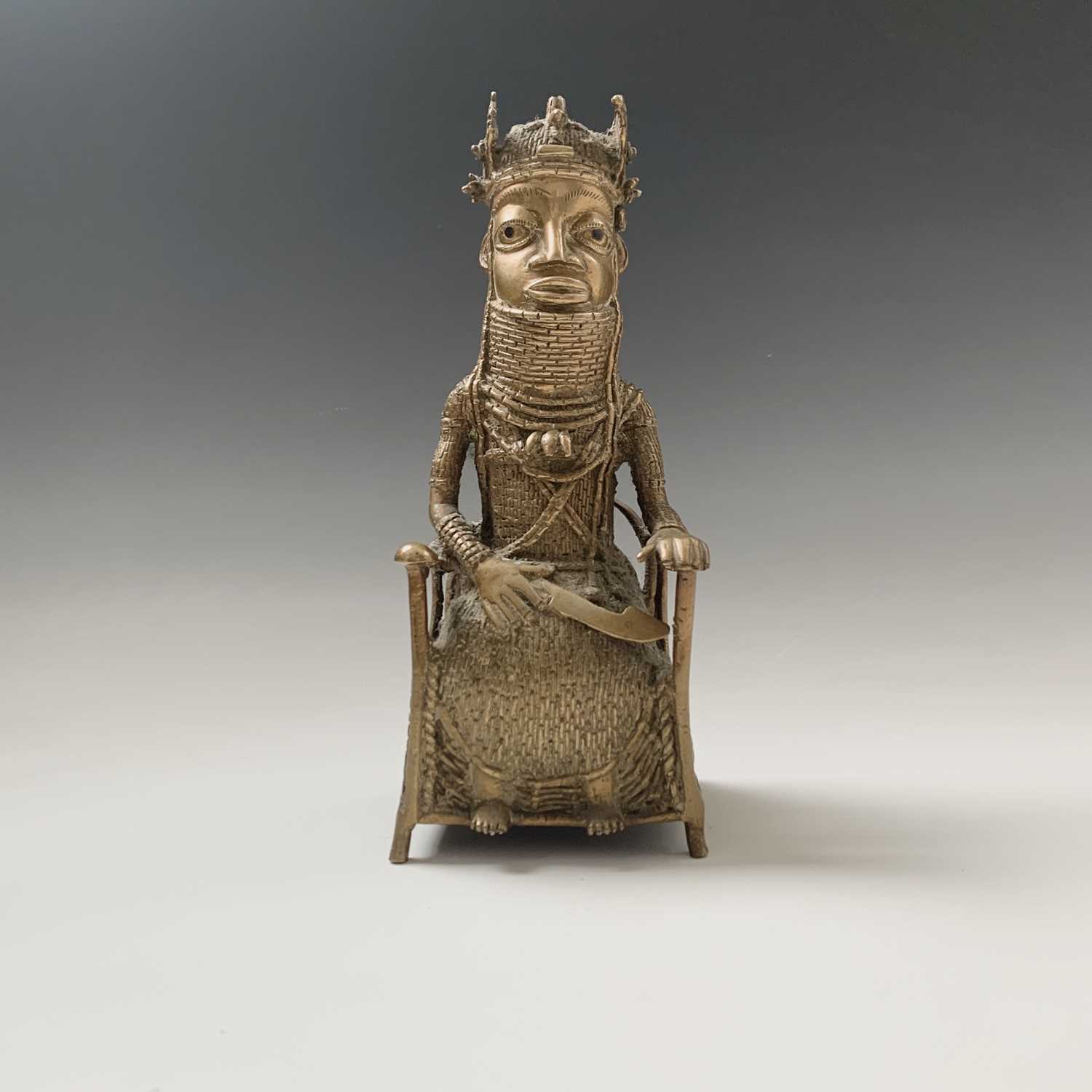 Lot 216 - A Bennin bronze model of a seated chief,...