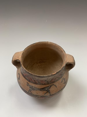 Lot 91 - A Chinese Neolithic earthenware pot, with twin...