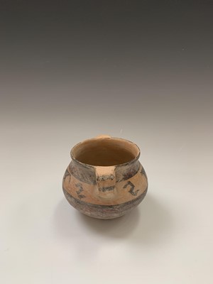 Lot 91 - A Chinese Neolithic earthenware pot, with twin...