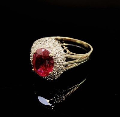 Lot 736 - A gold oval diamond and red stone cluster ring