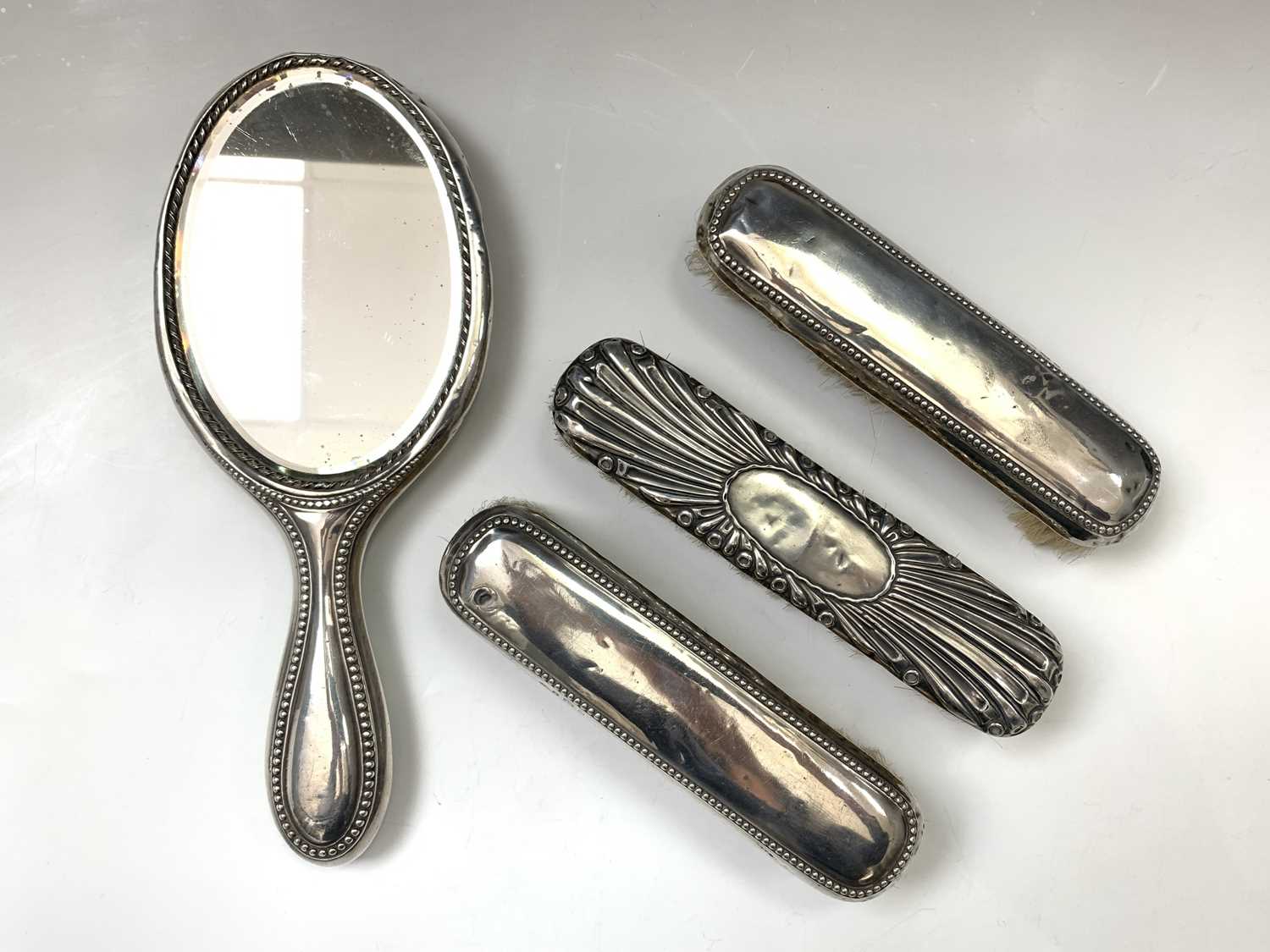 Lot 36 - A silver-mounted mirror and three...
