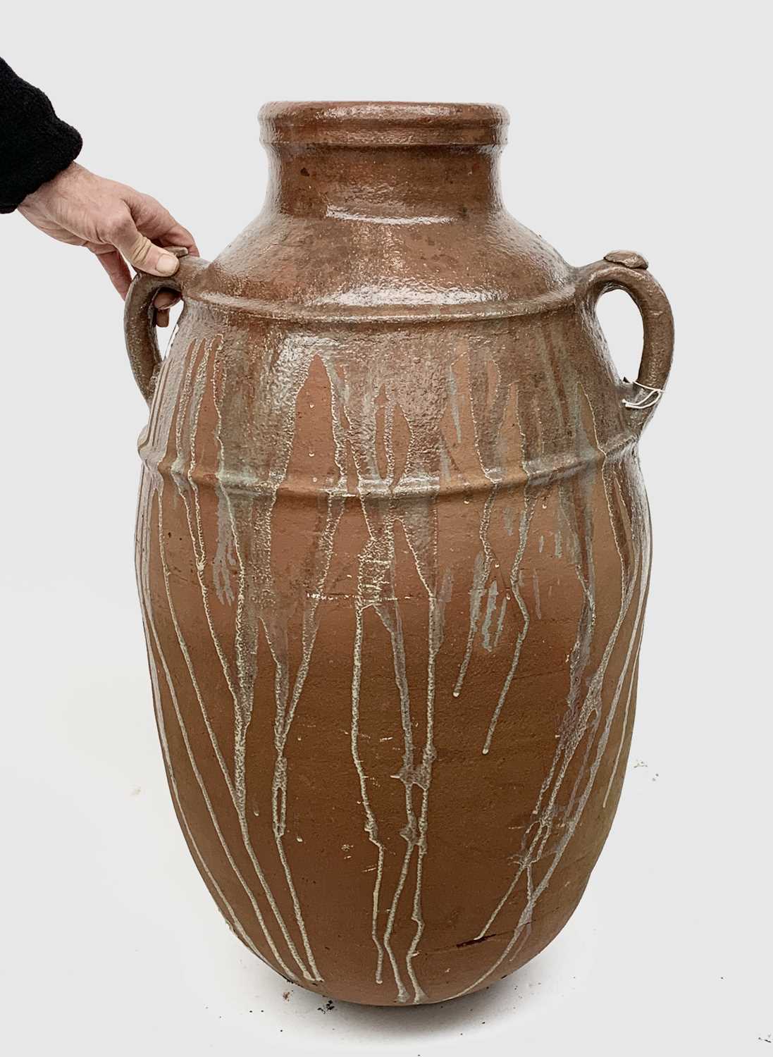 Lot 2004 - A large terracotta olive jar with twin handles....