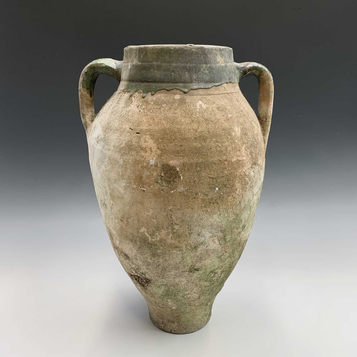 Lot 385 - A terracotta olive jar with green glazed rim....