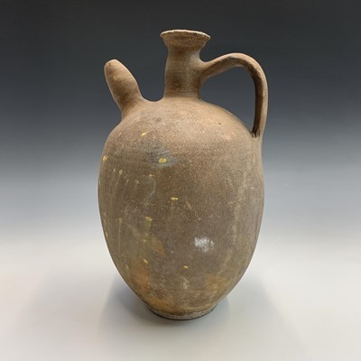 Lot 383 - A terracotta spouted jar with handle. Height...