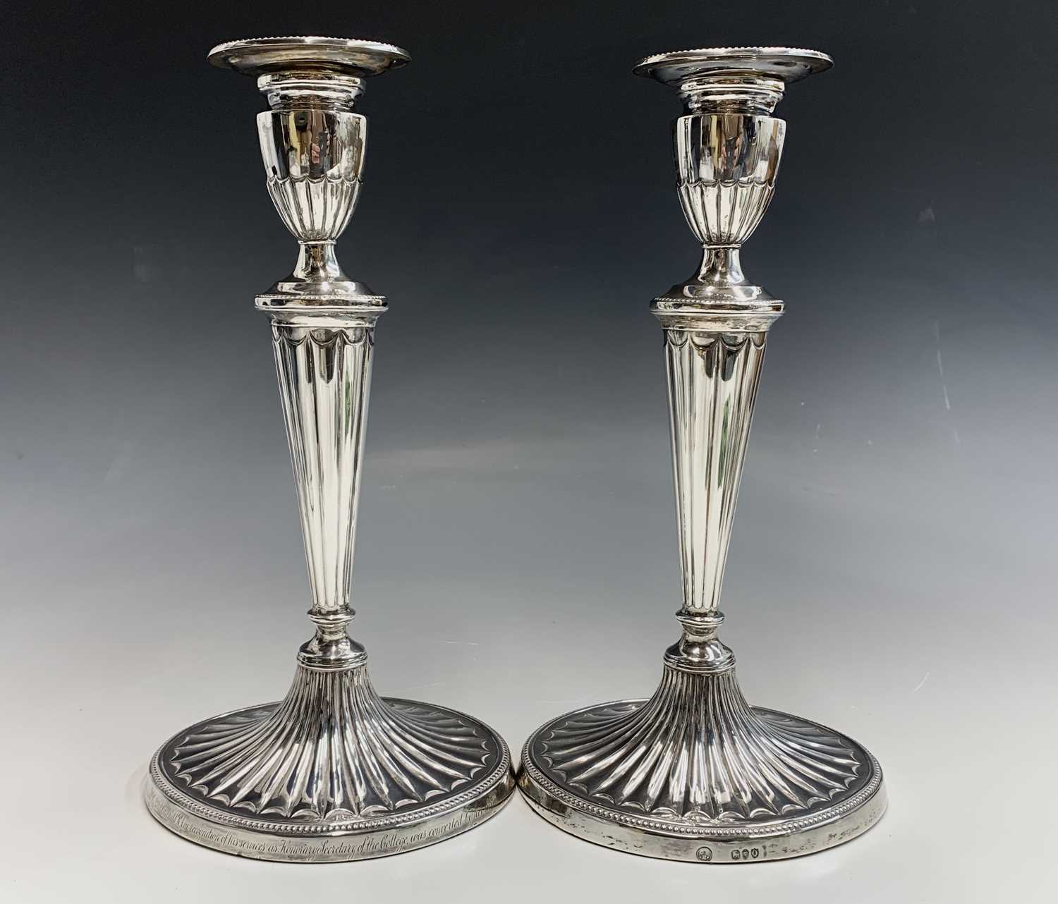 Lot 110 - A pair of Adam style silver candlesticks by...