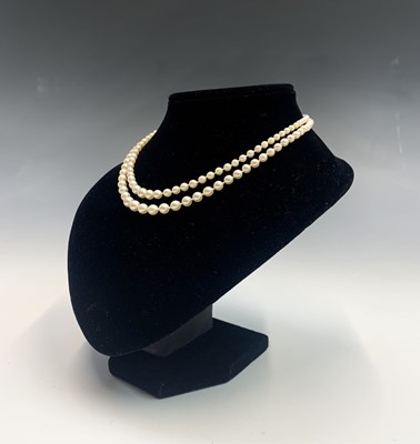 Lot 562 - A double-strand graduated pearl necklace with...