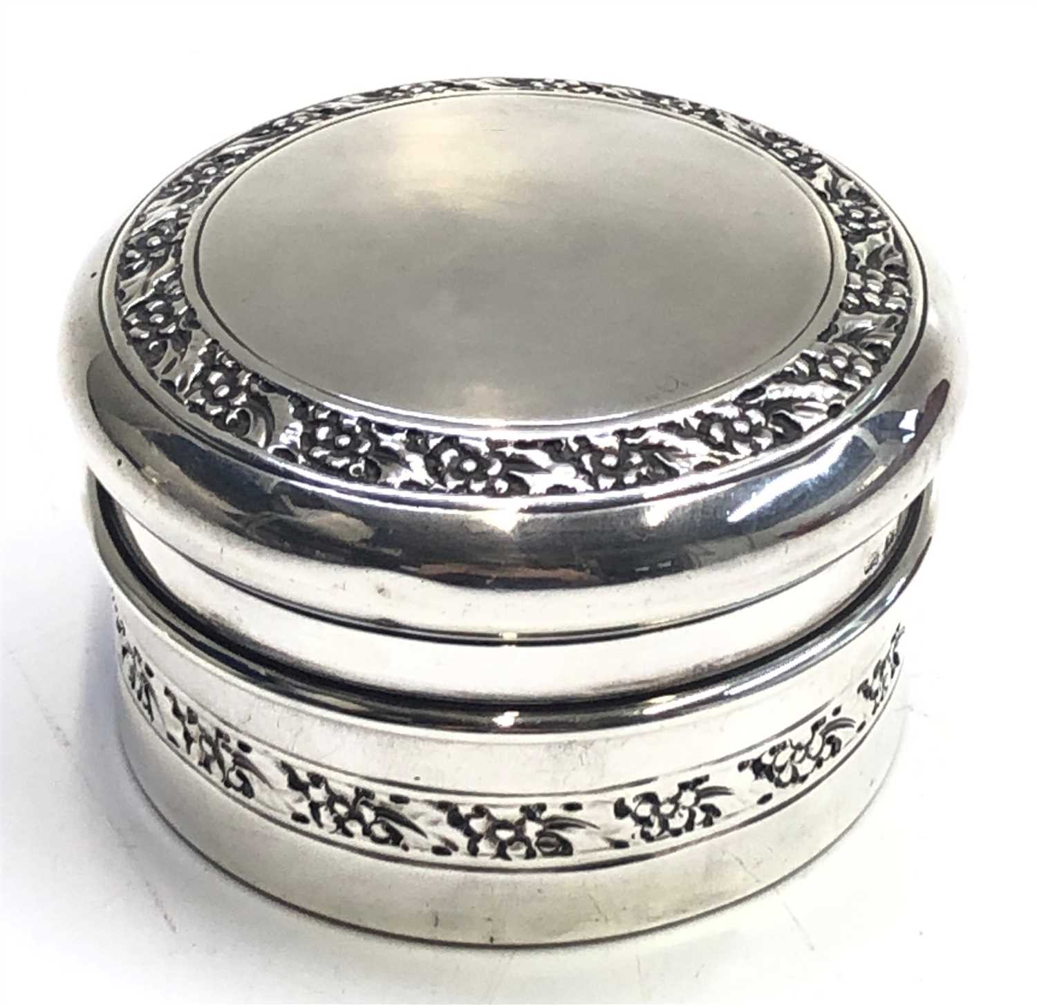 Lot 2088 - A lidded round silver box with two bands of...