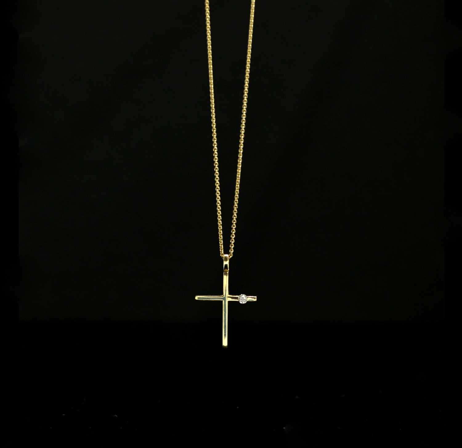 Lot 558 - An 18ct gold cross set a diamond on 18ct gold...