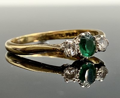 Lot 461 - An 18ct gold ring set an emerald and two diamonds
