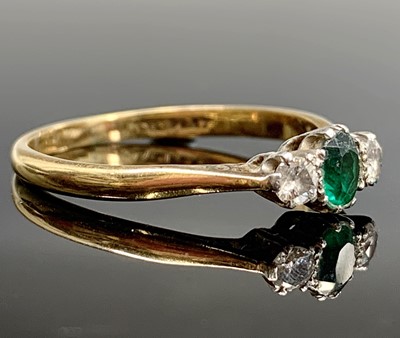 Lot 221 - An 18ct gold ring set an emerald and two diamonds