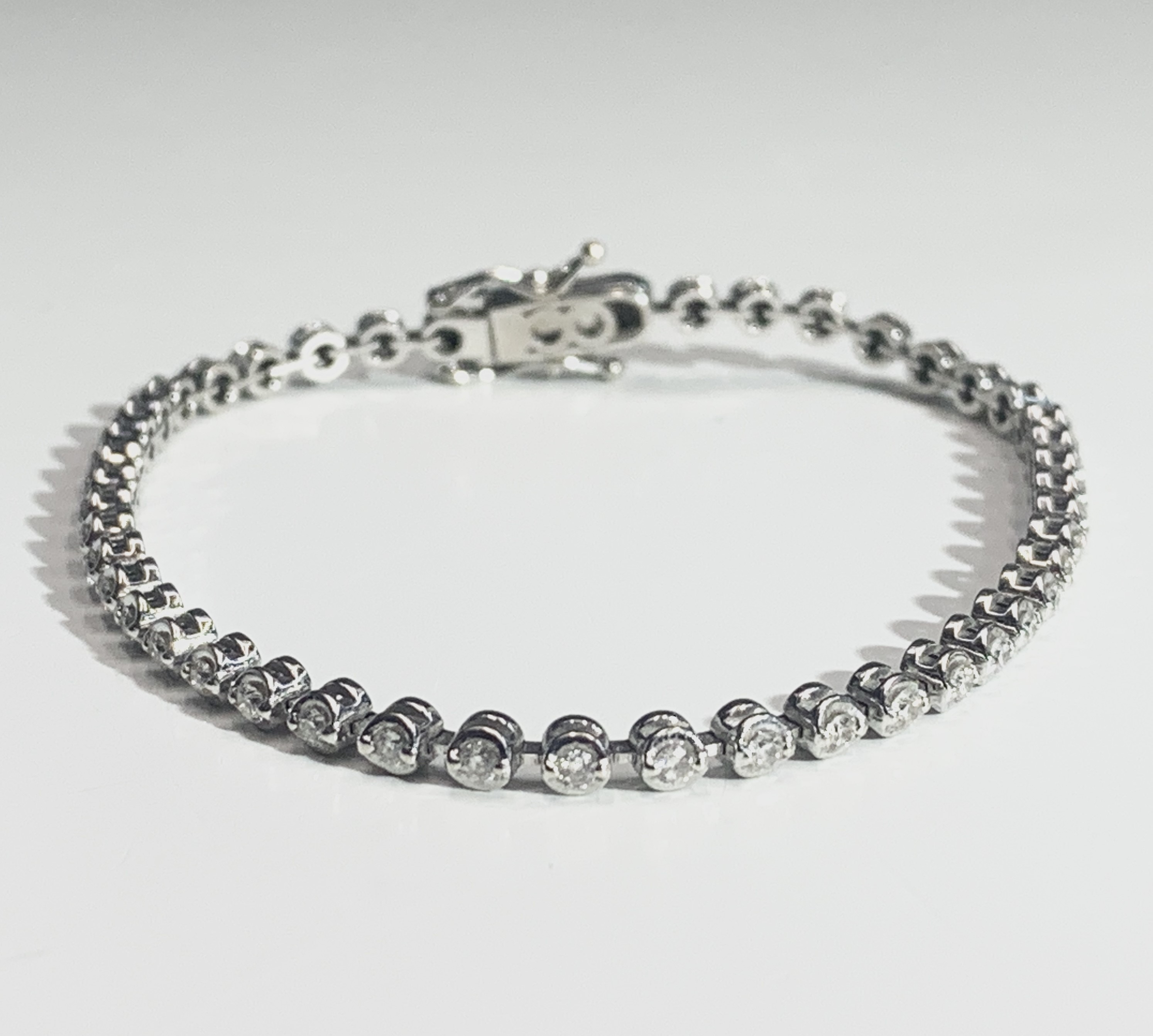 Lot 664 - An 18ct white gold tennis bracelet, set with
