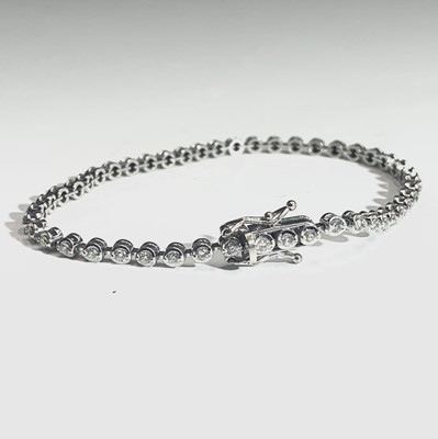 Lot 664 - An 18ct white gold tennis bracelet, set with a...