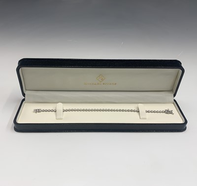 Lot 664 - An 18ct white gold tennis bracelet, set with a...