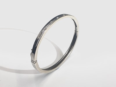 Lot 312 - A contemporary 18ct white gold hinged bangle...