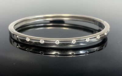 Lot 312 - A contemporary 18ct white gold hinged bangle...