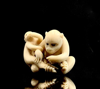 Lot 6 - A Japanese ivory netsuke of a monkey with her...