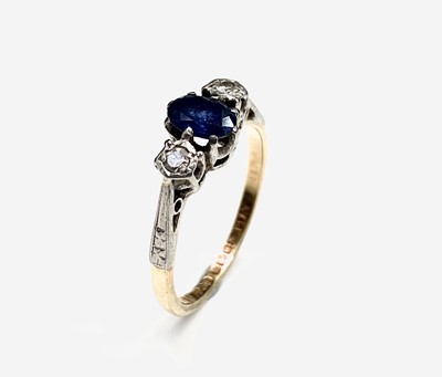 Lot 626 - An 18ct gold ring set an oval sapphire and two...