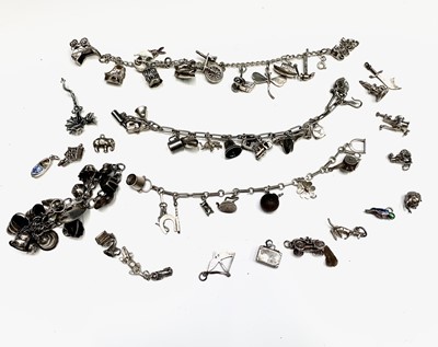 Lot 268 - A large collection of silver charms on three bracelets and loose.