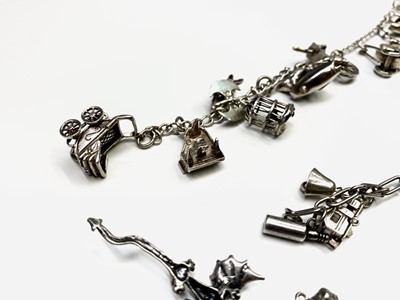 Lot 268 - A large collection of silver charms on three bracelets and loose.