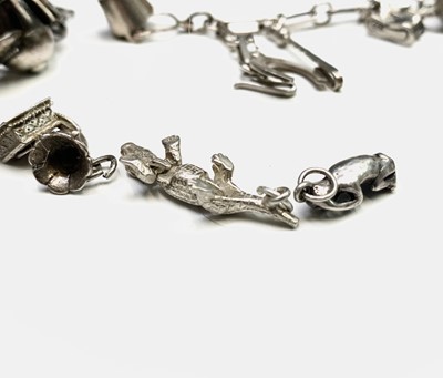 Lot 268 - A large collection of silver charms on three bracelets and loose.